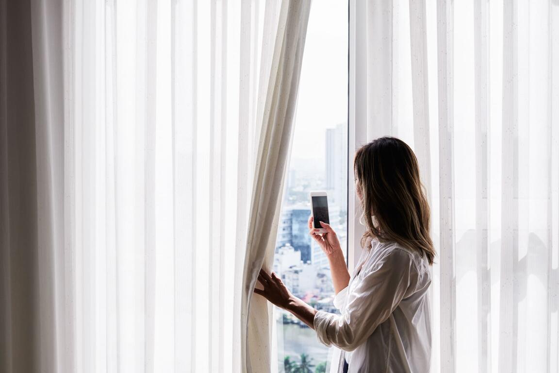 Woman looking outside in front of her window